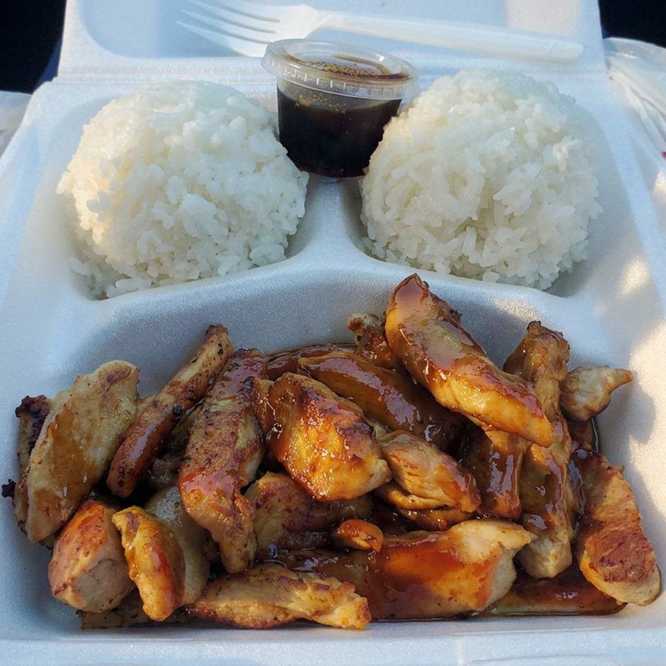 Takeout container filled with glazed grilled chicken pieces, two scoops of white rice, and a small cup of dark sauce.